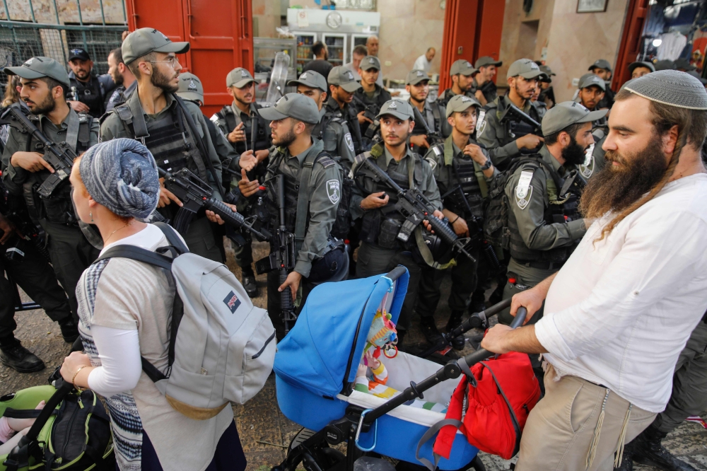 Israeli security forces stand guard as Jewish orthodox tour the old city of Jerusalem on June 2, 2019 marking Jerusalem Day.  AFP / Menahem Kahana 