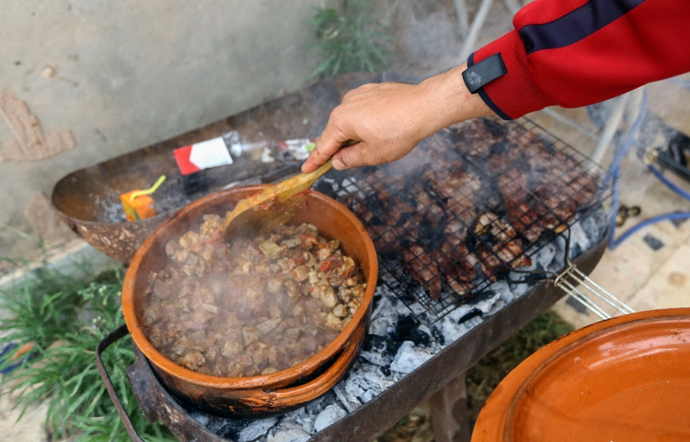 A fighter loyal to the Libyan internationally-recognised Government of National Accord (GNA) prepares the Iftar meal for fellow fighters before breaking their fast at the front lines on MAY 31, 2019, in the suburb of Al-Swani, 25 kilometres south of Tripo