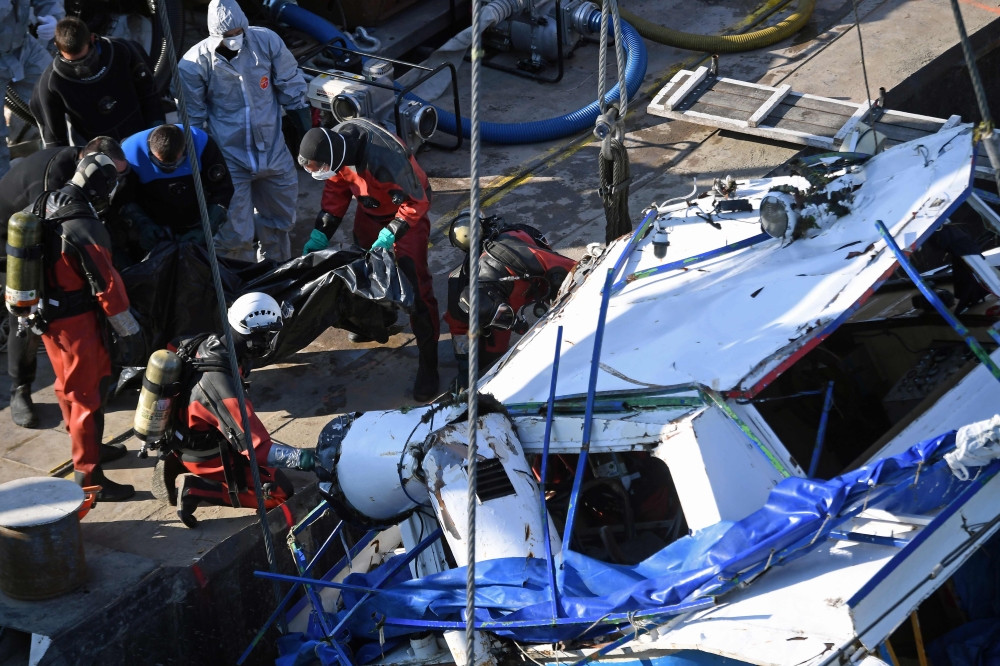 Rescue workers recover a body as they lift the sunken sightseeing boat 