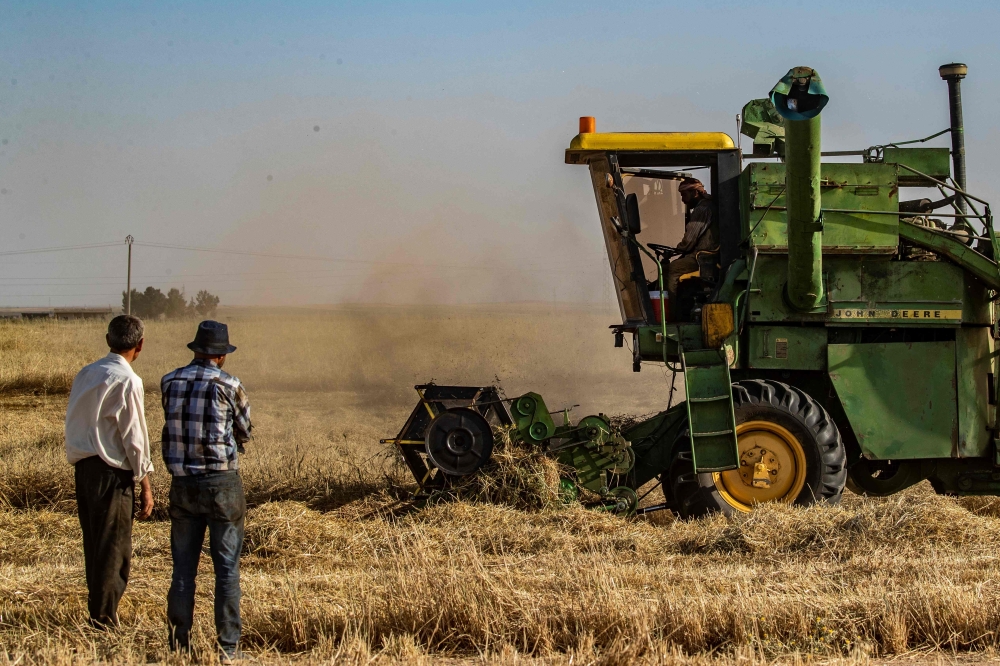 A picture taken on May 21, 2019, shows a combine harvester harvesting a wheat field in Syria's northeastern region of Hasakeh. AFP / DELIL SOULEIMAN