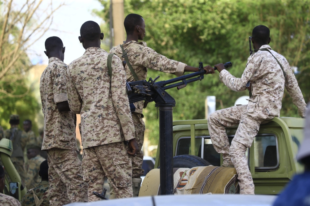 Members of Sudan's Rapid Support Forces (RSF) paramilitaries wait in a security detail as the country's ousted president appears before prosecutors over charges of corruption and illegal possession of foreign currency, in the capital Khartoum on June 16, 