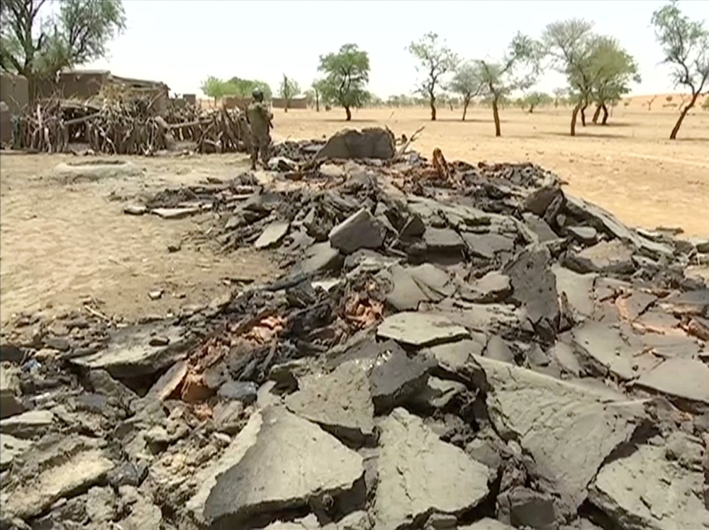 A soldier stands near debris from destroyed homes at the site of an ethnic massacre in which gunmen killed dozens of people, in the Dogon village of Sobane Da, Mali June 13, 2019, in this still image taken from video.