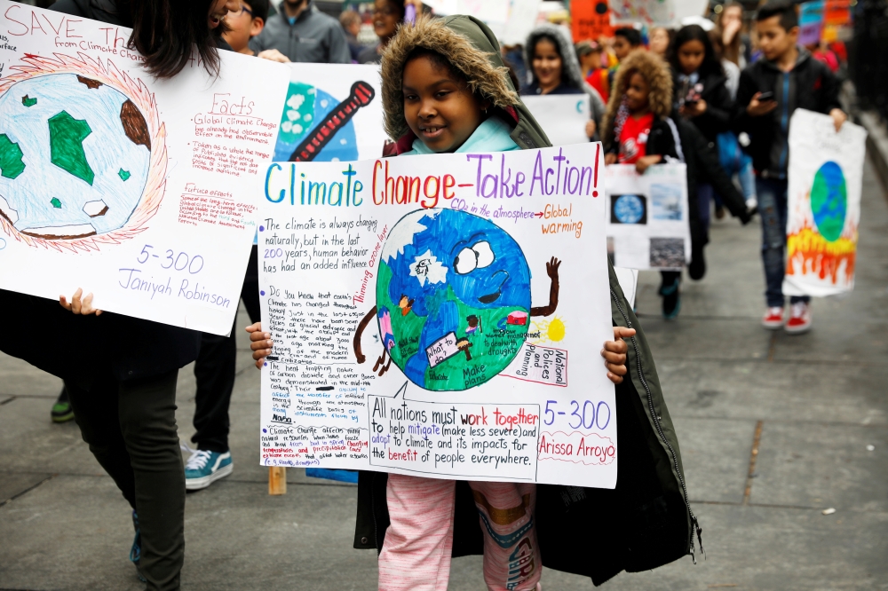FILE PHOTO: Students hold banners and placards during a demonstration against climate change in New York, United States, March 15, 2019. REUTERS/Shannon Stapleton/File Photo