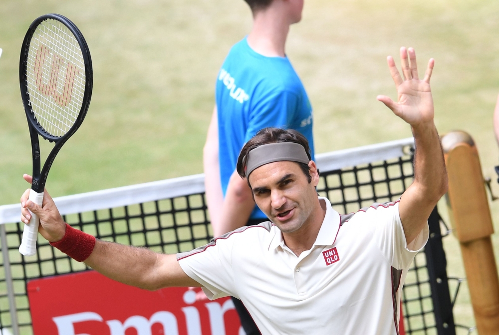 Roger Federer from Switzerland reacts after he won his match against Pierre-Hugues Herbert from France at the ATP tennis tournament in Halle, western Germany, on June 22, 2019. / AFP / CARMEN JASPERSEN