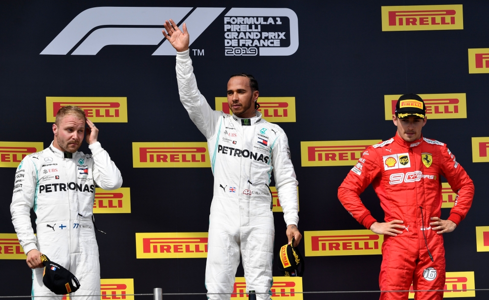 Winner Mercedes' British driver Lewis Hamilton (C) celebrates on the podium next to second placed Mercedes' Finnish driver Valtteri Bottas (L) and third placed Ferrari's Monegasque driver Charles Leclerc (R) after the Formula One Grand Prix de France at t