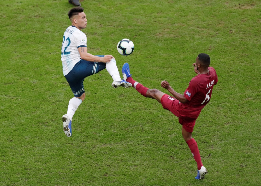 Argentina's Lautaro Martinez in action with Qatar's Abdelaziz Mohamed. Reuters/Ueslei Marcelino
