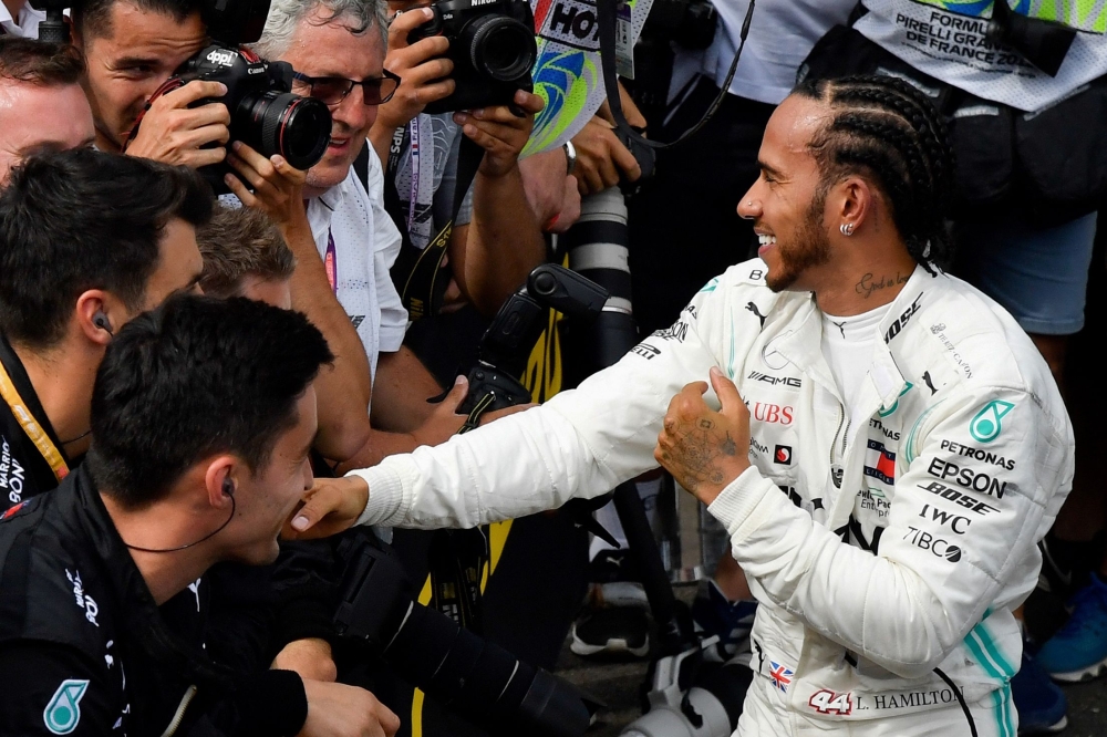 Winner Mercedes' British driver Lewis Hamilton (R) is congratulated by team-mates after the Formula One Grand Prix de France at the Circuit Paul Ricard in Le Castellet, southern France, on June 23, 2019. / AFP / GERARD JULIEN