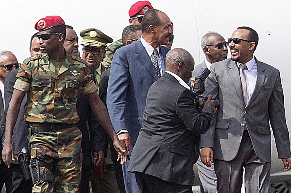 FILE PHOTO: Eritrea President Isaias Afwerki (C) is welcomed by Ethiopia Prime Minister of Abiy Ahmed (R) and Seare Mekonnen (C left) as he arrives at the Bole International airport in Addis Ababa on July 14, 2018. / AFP / MAHEDER HAILESELASSIE TADESE