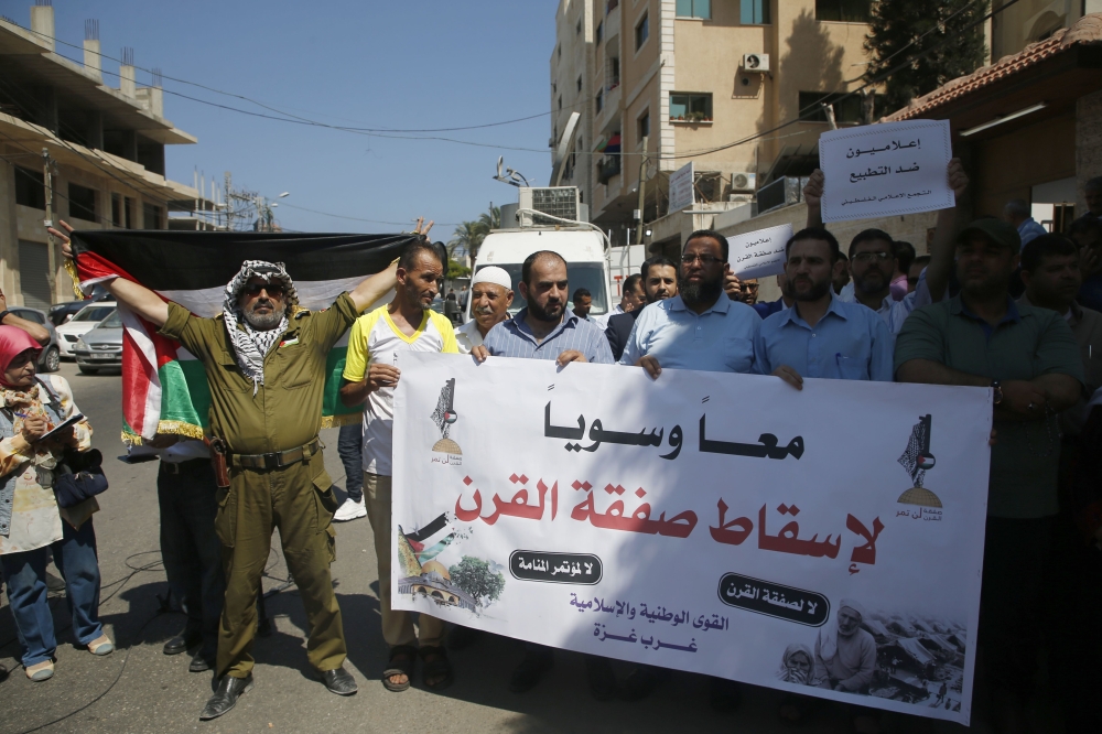 Paletinians hold banners denouncing the US-led Peace to Prosperity conference that opens tomorrow in Bahrain, in Gaza City on June 24, 2019.   AFP / MOHAMMED ABED