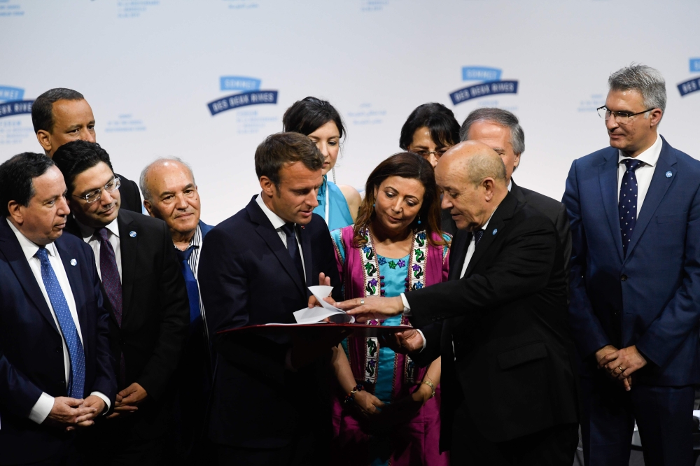 French President Emmanuel Macron (C-L) listens to his French Foreign Affairs Minister Jean-Yves Le Drian duirng the Mediterranean Summit (The Sommet des Deux Rives/Summit of the Two Shores ) which is being held in the city of Marseille, southern France, o