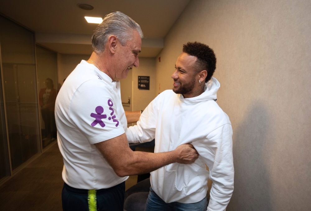 Brazilian player Neymar (R) is greeted by Brazil team coach Tite as he visits his teammates at the hotel where the team is staying during the 2019 Copa America in Sao Paulo, Brazil on June 21, 2019. / AFP / Brazilian Football Confederation (CBF) / Lucas F