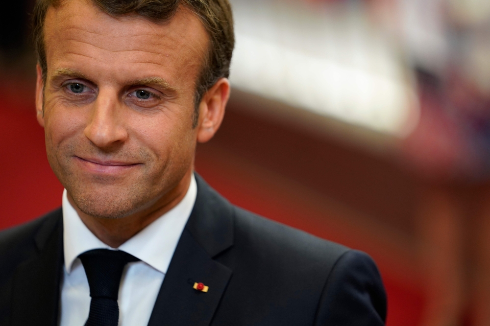 FILE PHOTO: French President Emmanuel Macron speaks to the press as he leaves after a European Union (EU) summit at the EU Headquarters in Brussels on the first day of a summit of EU leaders.  AFP / KENZO TRIBOUILLARD
