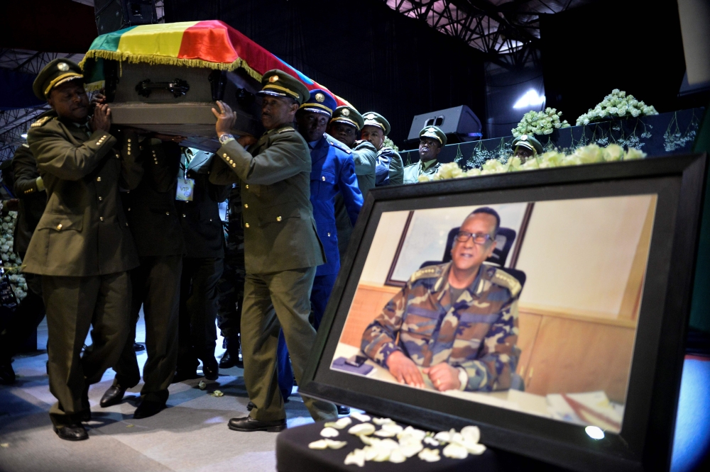 Members of the army carry one of the coffins covered with the Ethiopian national flag as they arrive at the millennium hole in Addis Ababa, on June 25, 2019 for the National funeral service of Chief of Staff of the Ethiopian defence forces Seare Mekonnen 