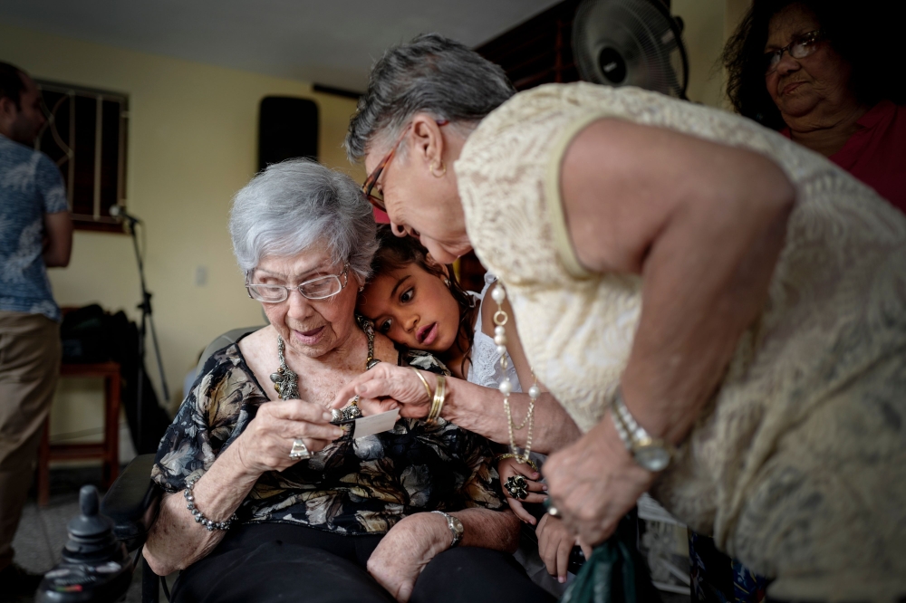 Cuban Delia Barroso, 102, receives a present during her birthday in Havana, on May 18, 2019. AFP / ADALBERTO ROQUE