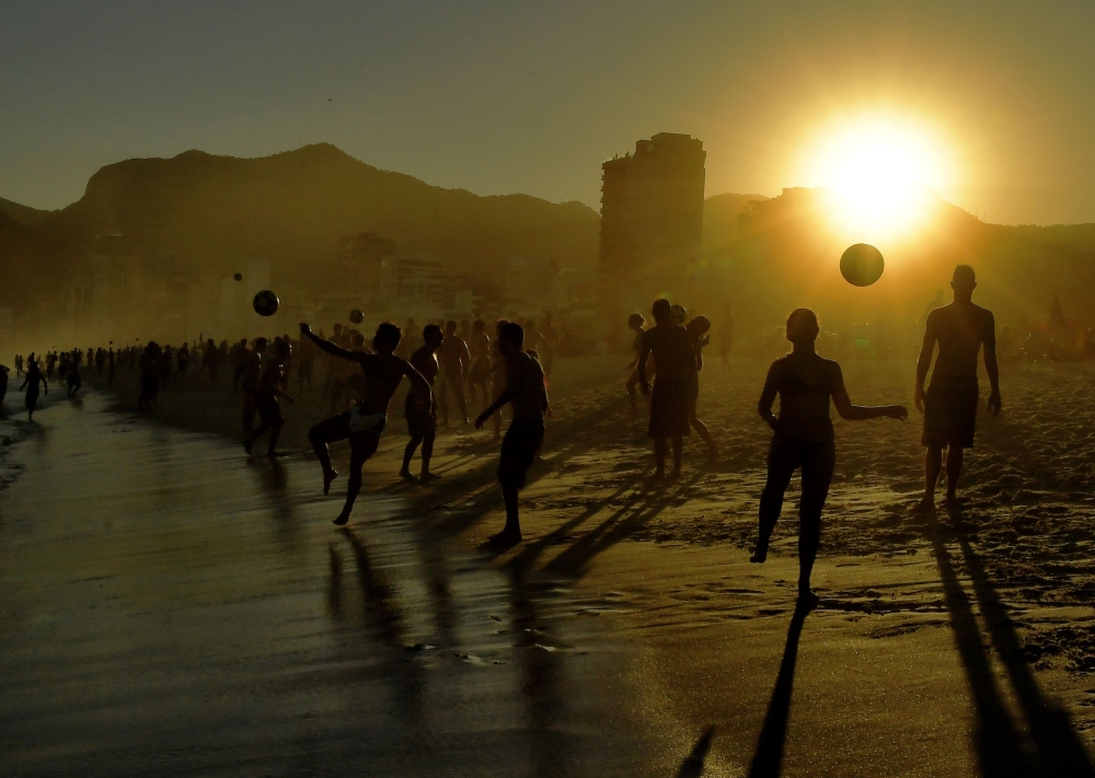 Beachgoers play with balls at Ipanema Beach in Rio de Janeiro, Brazil, on June 29, 2019. Tourists from all over Latin America have arrived in Rio for the Copa America football tournament. AFP / Carl De Souza 