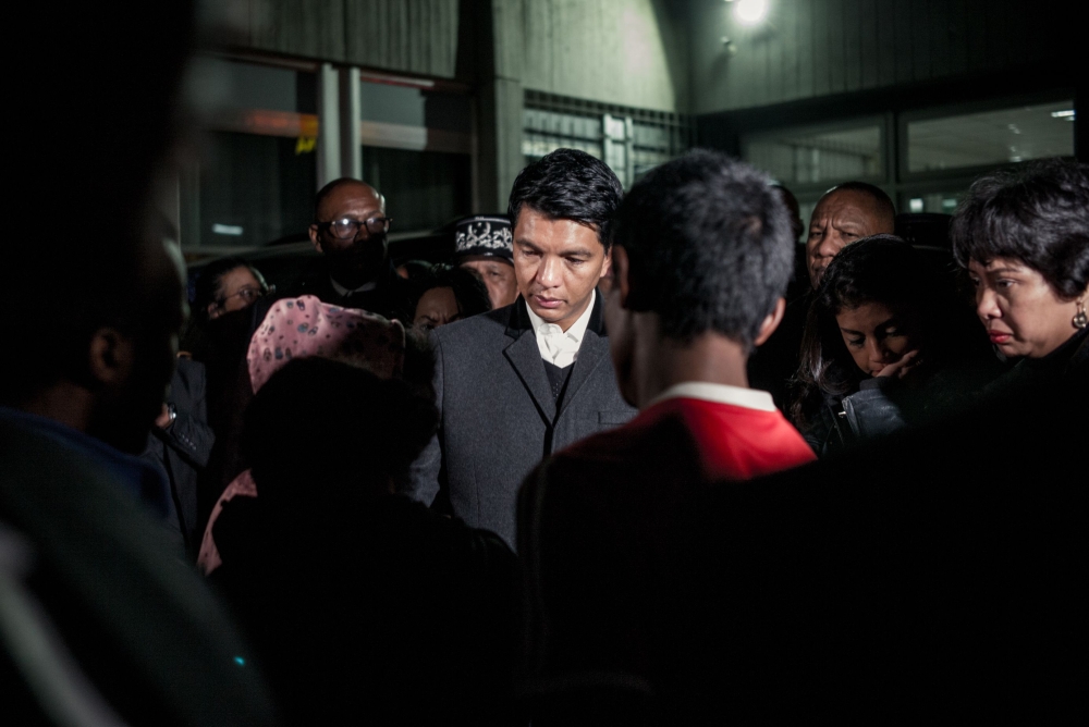 President of the Republic of Madagascar Andry Rajoelina (C) talks with families of victims at Joseph Ravoahangy Andrianavalona Hospital (HJRA) in Antananarivo late on June 26, 2019.  AFP/ Rijasolo 