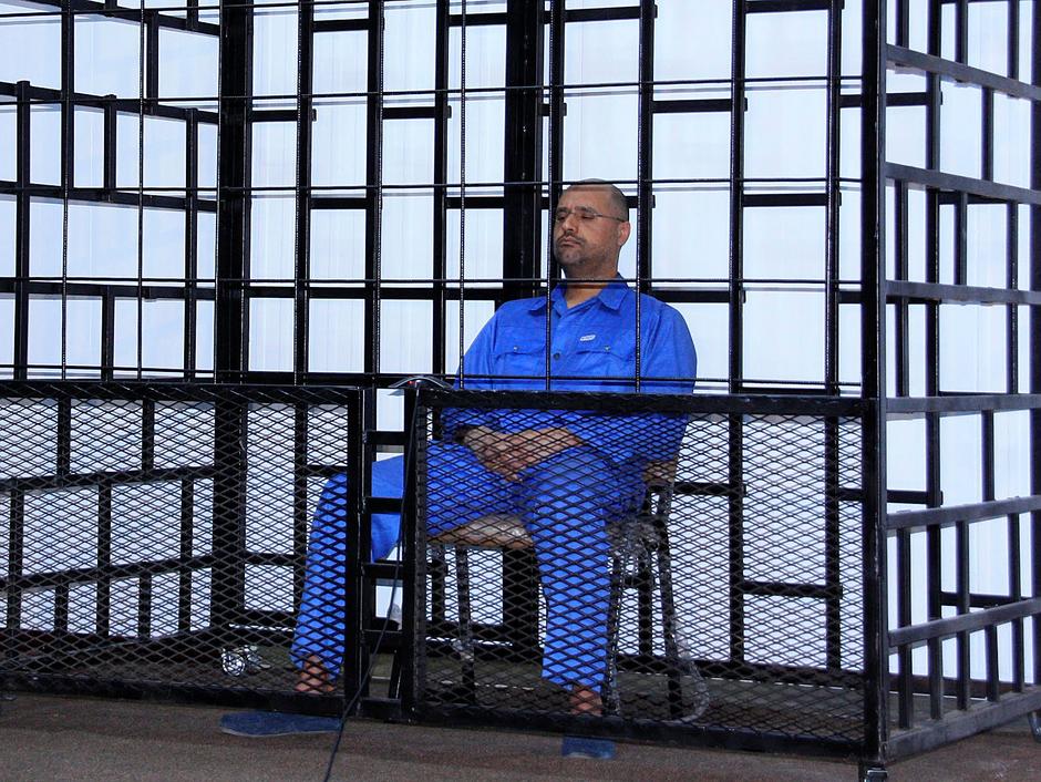 Saif al-Islam Gaddafi, son of late Libyan leader Muammar Gaddafi, attends a hearing behind bars in a courtroom in Zintan May 25, 2014. Reuters