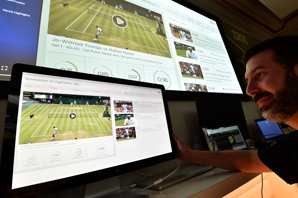 An IBM technician poses with screens showing IBM's AI-generated highlights of play on the sixth day of the 2019 Wimbledon Championships at The All England Lawn Tennis Club in Wimbledon, southwest London, on July 6, 2019.  AFP / Glyn Kirk