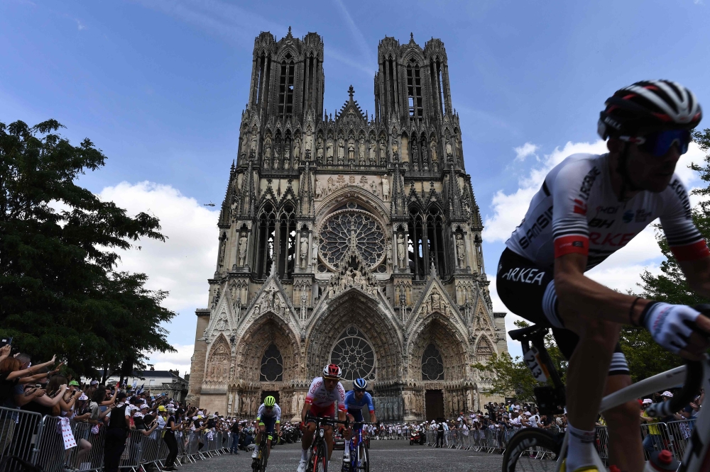 The pack rides with the Cathedral of reims in background during the third stage of the 106th edition of the Tour de France cycling race between Binche and Epernay, in Reims, on July 8, 2019. AFP / Jeff Pachoud
 
 