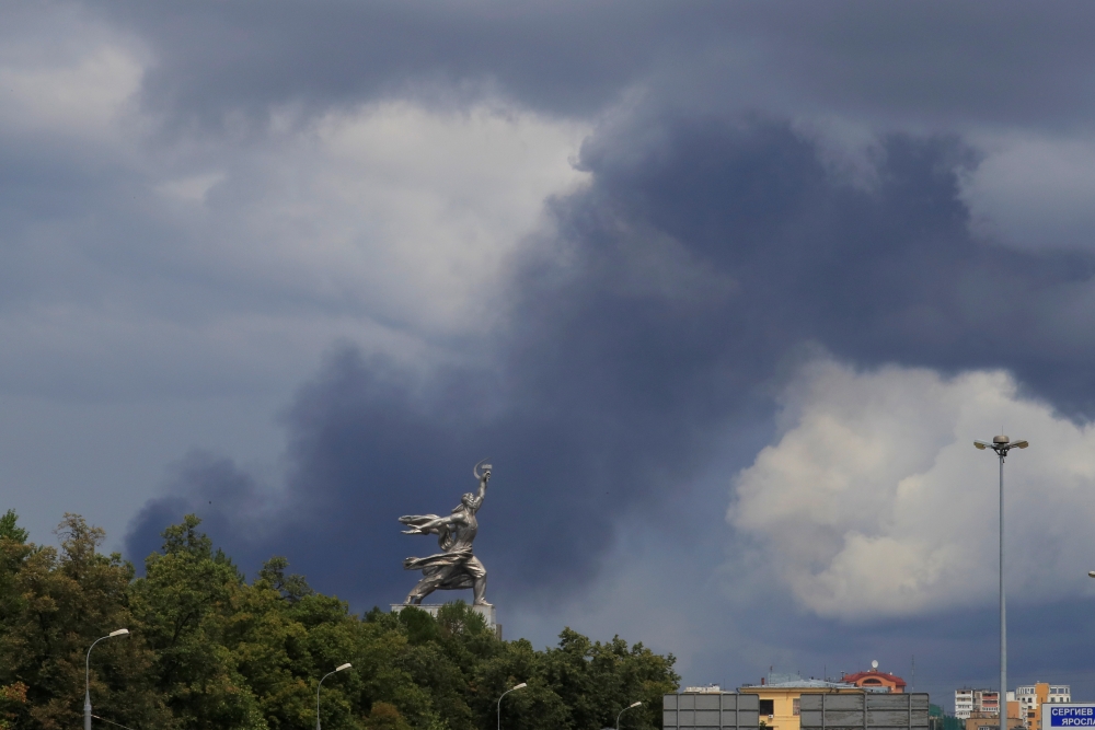 Smoke rises from a fire at an electricity generating power station in Moscow region as a sculpture of 