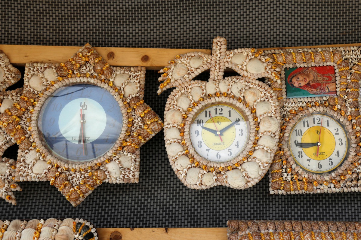 Wall clocks decorated with seashells of various shapes and colors are put up for sale along Clifton beach in Karachi, Pakistan, July 9, 2019. Reuters/Akhtar Soomro 
