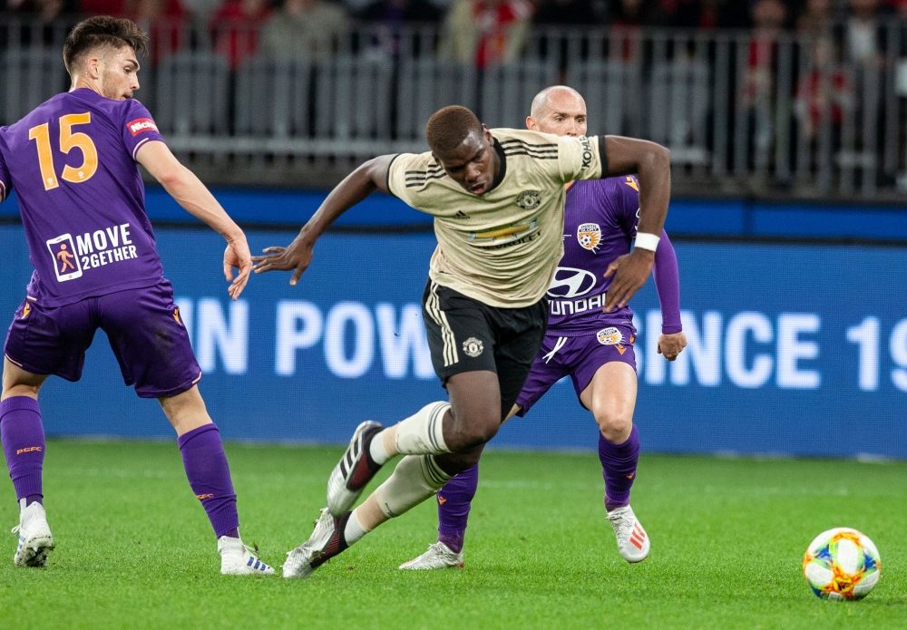 Manchester Paul Pogba (C) fights for the ball with Perth Glory's Chris Harold (L) and Gabriel Popovic (R) during their pre-season friendly match at Optus Stadium in Perth on July 13, 2019. (AFP / TONY ASHBY)