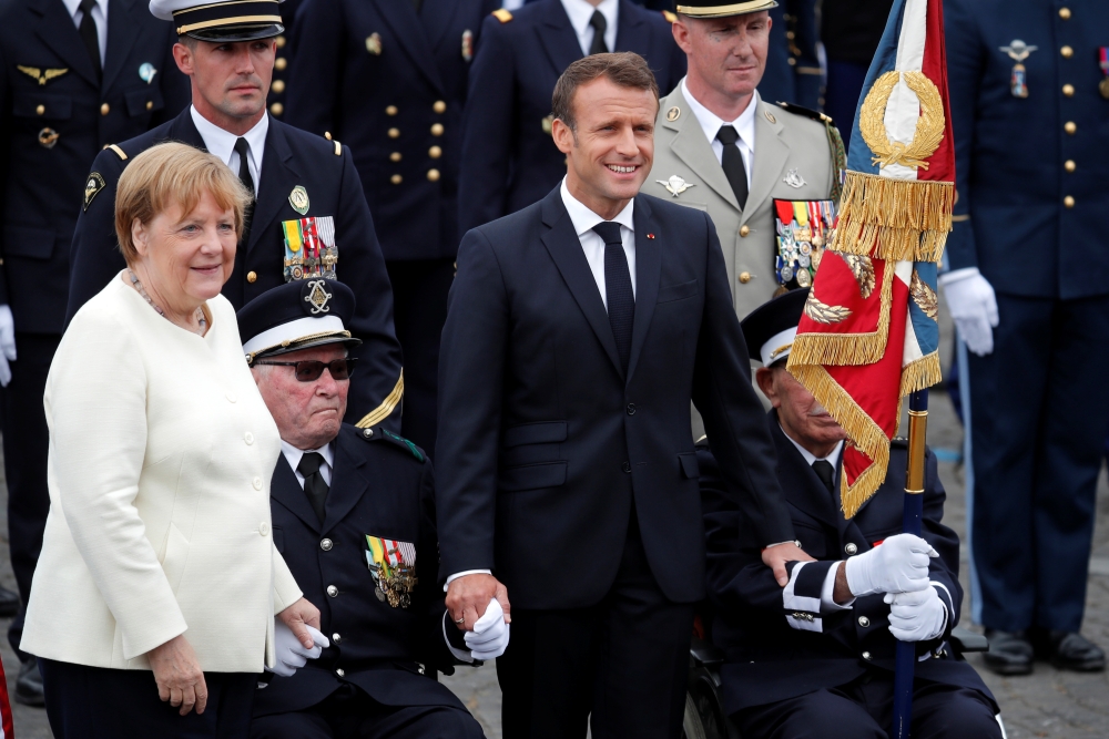 German Chancellor Angela Merkel and French President Emmanuel Macron attend the traditional Bastille Day military parade on the Champs-Elysees Avenue in Paris, France, July 14, 2019. Reuters/Charles Platiau