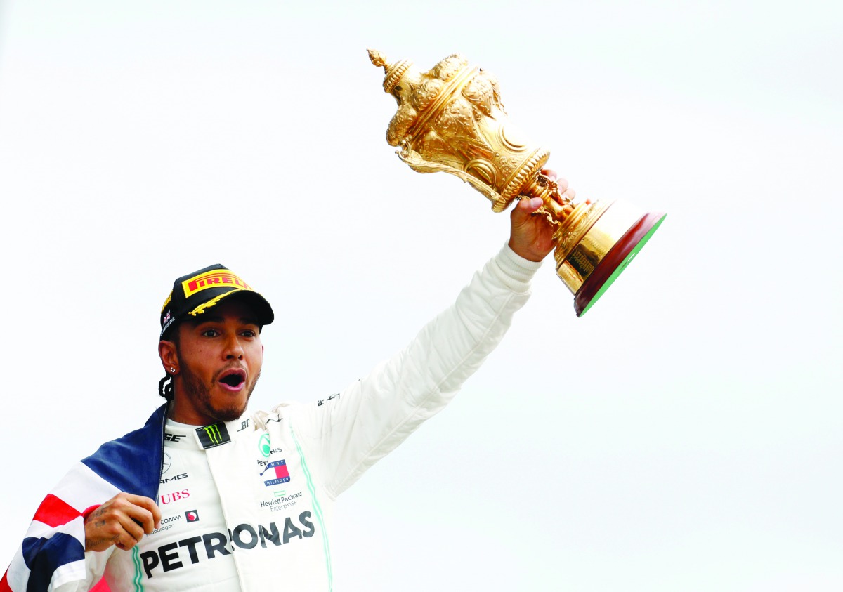  Mercedes' Lewis Hamilton celebrates with the trophy after winning the race. Reuters/John Sibley 