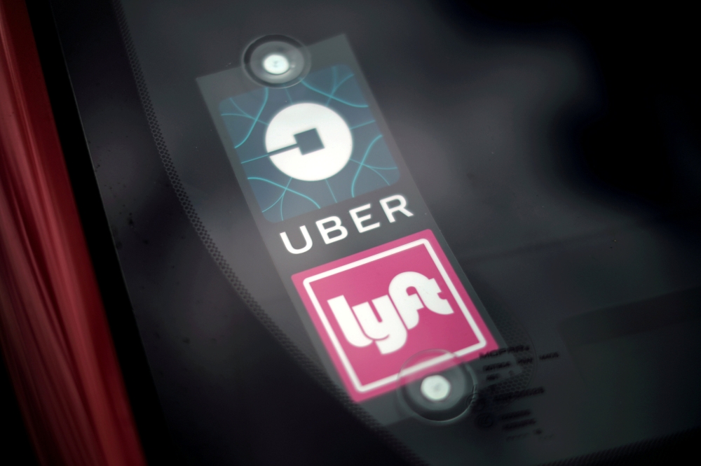 Uber and Lyft signs are seen on a car in Redondo Beach, California, March 25, 2019. Reuters / Lucy Nicholson