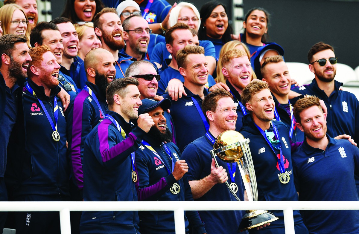England’s captain Eoin Morgan holds the trophy as he poses with team-mates during a World Cup victory event at the Oval in London, yesterday. 