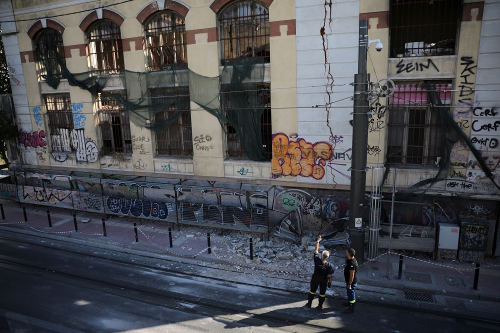 Firefighters look at a damaged abandoned building following an earthquake, in Piraeus, near Athens, Greece, July 19, 2019. Reuters/Alkis Konstantinidis