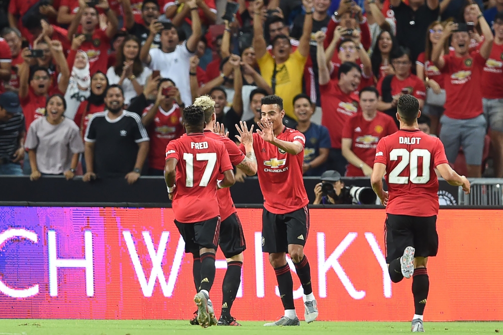 Manchester United's Mason Greenwood (2nd R) is congratulated by teammates after scoring during the International Champions Cup football match between Manchester United and Inter Milan in Singapore on July 20, 2019. (AFP / Roslan RAHMAN)