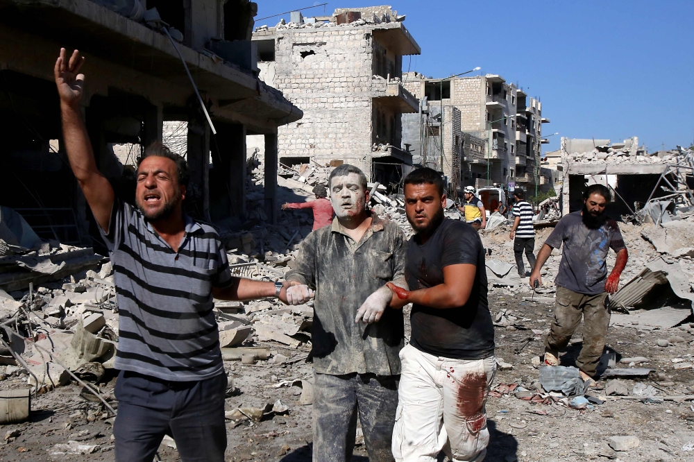 Syrians help a man pulled out from the rubble of a destroyed building following a Russian air strike on July 22, 2019 on Maaret al-Numan in Syria's northwestern Idlib province in the latest violence to plague the opposition bastion, as the Damascus regime