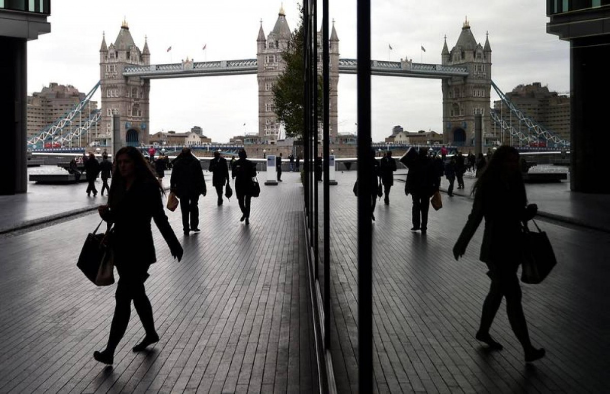 Workers walk through the More London business district with Tower Bridge seen behind in London, November 11, 2015. Reuters / Toby Melville