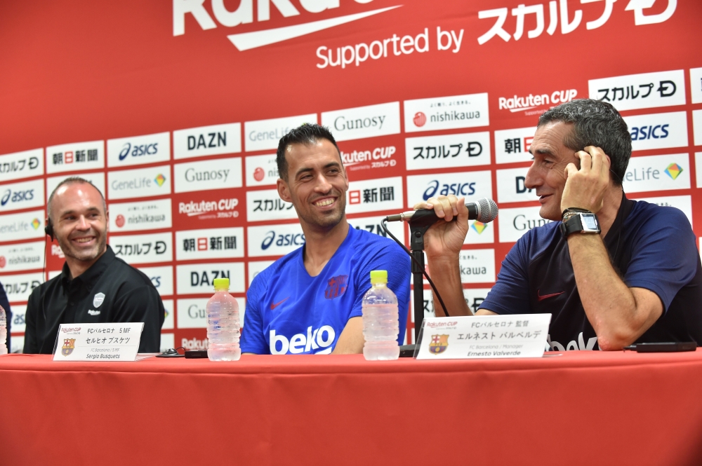 FC Barcelona's Spanish head coach Ernesto Valverde (R) speaks while Barcelona's Sergio Busquets (C) and Vissel Kobe's Andres Iniesta (L) look on during a pre-match press conference ahead of the Rakuten Cup football match between Vissel Kobe and FC Barcelo