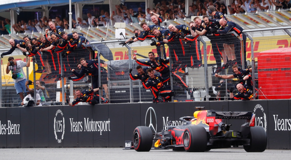 Red Bull's Max Verstappen crosses the line to win the race as Red Bull engineers celebrate (REUTERS/Kai Pfaffenbach)