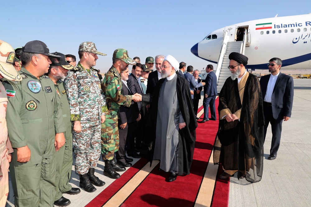 A handout picture shows Iran's President Hassan Rouhani(C) greeted on his arrival to Tabriz airport in the northwestern East-Azerbaijan province on August 1. (AFP / Iranian Presidency)