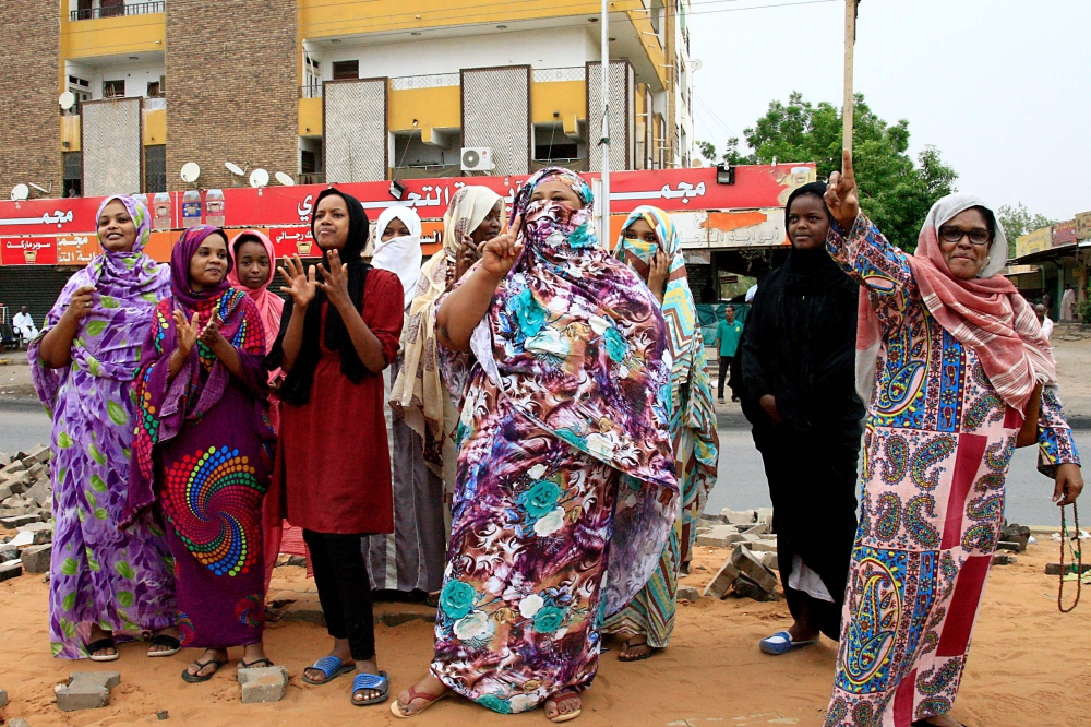 Sudanese demonstraters celebrate in Khartoum early on August 3, 2019, after Sudan's ruling generals and protest leaders reached a 