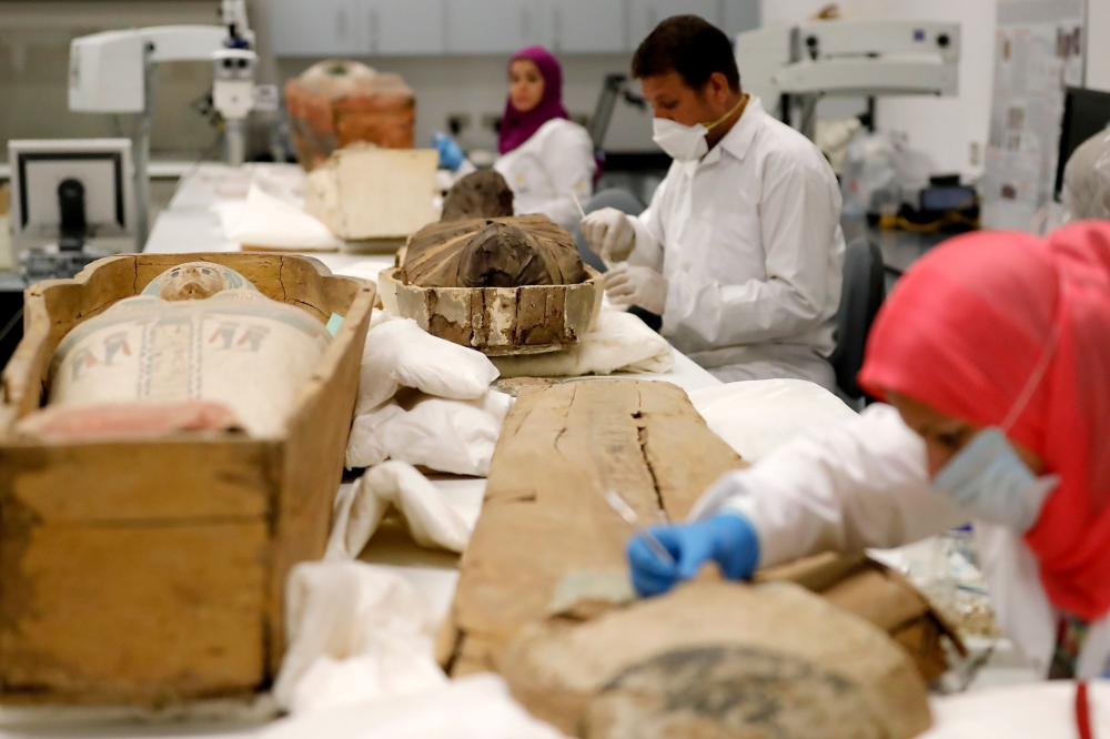 Egyptian archaeologists restore the coffin and mummy of King Tutankhamun at the conservation center in the Grand Egyptian Museum in Cairo on August 4, 2019.   AFP / Khaled DESOUKI
