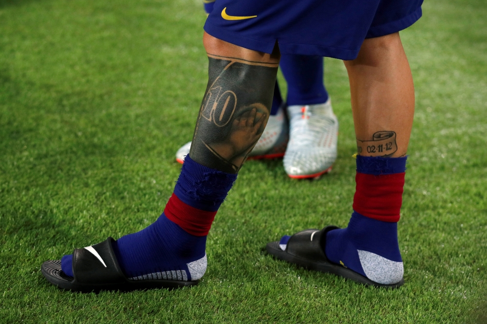 General view of tattoos on legs of Barcelona's Lionel Messi REUTERS/Albert Gea