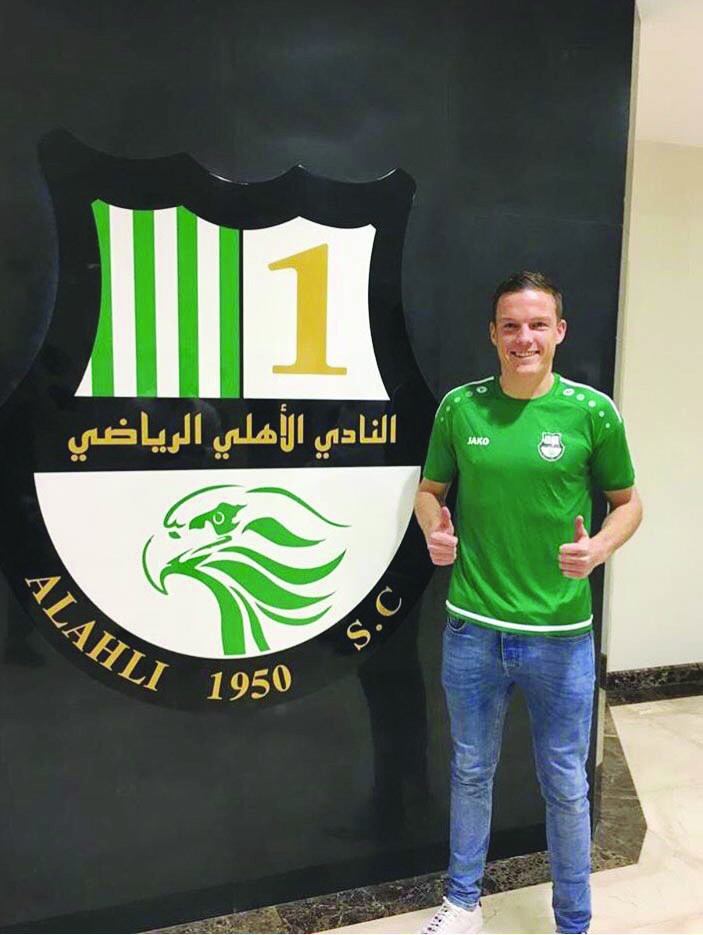 Australian defender Shane Lowry posing for a photograph in front of the logo of Al Ahli SC after joining the Qatari club yesterday. Picture: Twitter/@STLowry4