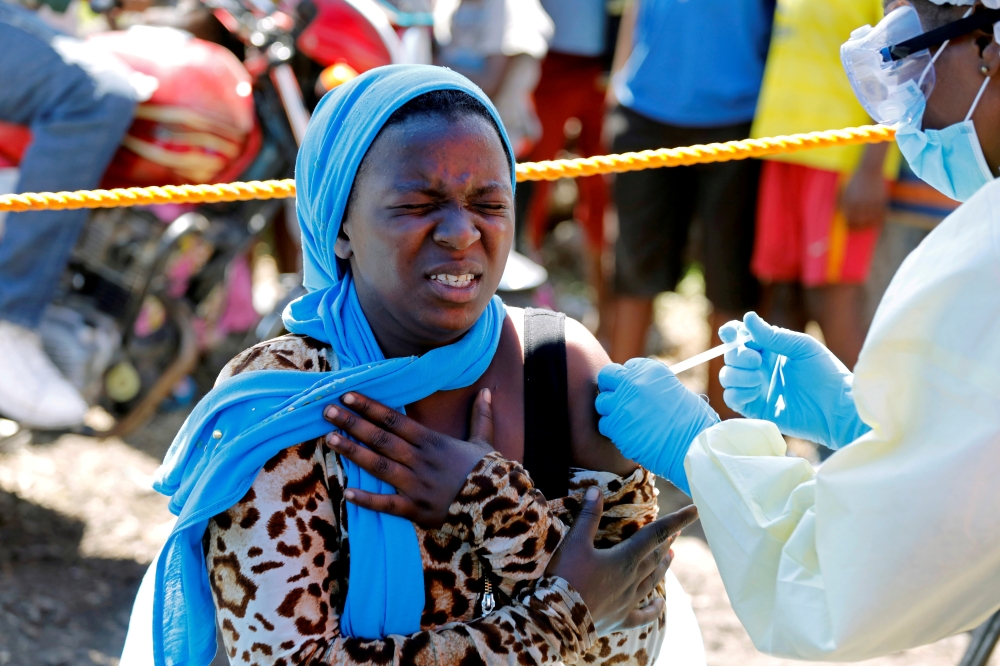 A young woman reacts as a health worker injects her with the Ebola vaccine, in Goma, Democratic Republic of Congo, August 5, 2019. REUTERS/Baz Ratner/File Photo