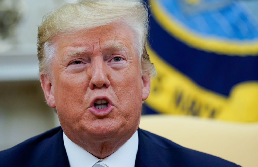 U.S. President Donald Trump answers questions from reporters as he meets with Romania's President Klaus Iohannis in the Oval Office of the White House In Washington, U.S. August 20, 2019. REUTERS/Kevin Lamarque