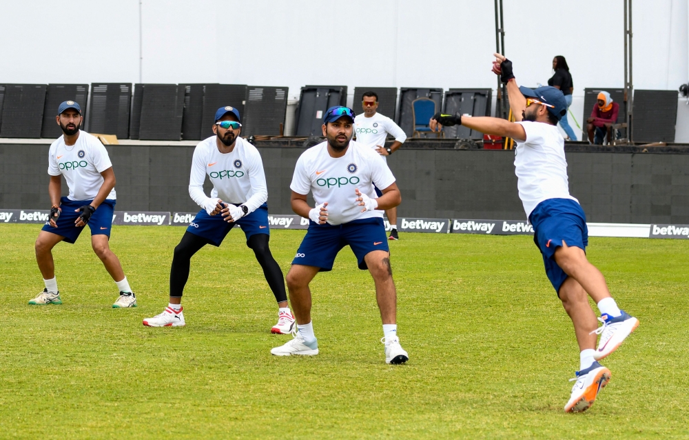 (From left) Cheteshwar Pujara, KL Rahul and Rohit Sharma watch Ajinkya Rahane (R) of India catch the ball during a training session one day ahead of the 1st Test between West Indies and India at Vivian Richards Cricket Stadium, North Sound, Antigua, on Au