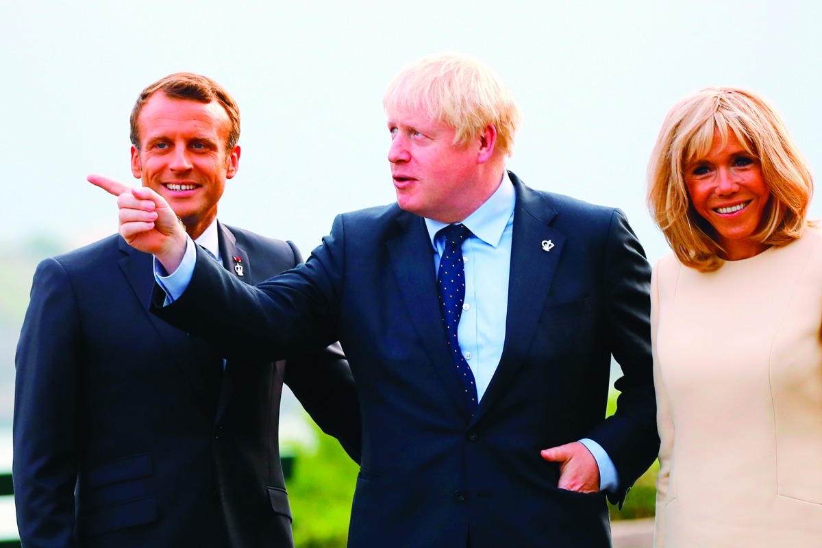 French President Emmanuel Macron (L) and his wife Brigitte welcome Britain's Prime Minister Boris Johnson (C) at the Biarritz lighthouse, southwestern France, ahead of a working dinner on August 24, 2019. AFP / Pool / Francois Mori
