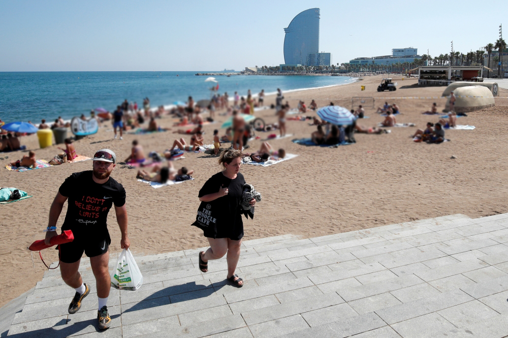 People leave Sant Sebastia beach after police found an explosive device in the water and evacuated part of it, possibly from the Spanish Civil War, in Barcelona, Spain August 25, 2019. REUTERS/Albert Gea	