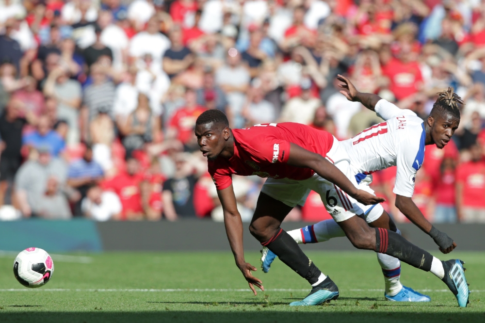 Manchester United's French midfielder Paul Pogba (L) vies with Crystal Palace's Ivorian striker Wilfried Zaha (R) during the English Premier League football match between Manchester United and Crystal Palace at Old Trafford in Manchester, north west Engla
