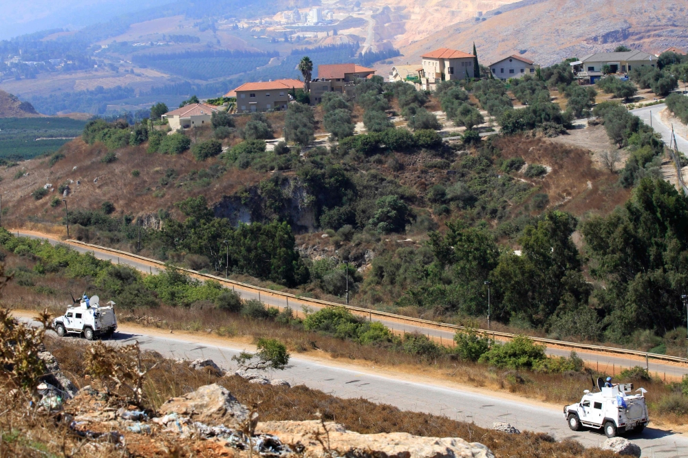 A photograph taken from El-Hamames hilltop in southern Lebanon shows vehicles belonging to the United Nations Interim Forces in Lebanon (UNIFIL) patrolling along the border with Israel, on August 26, 2019.  
