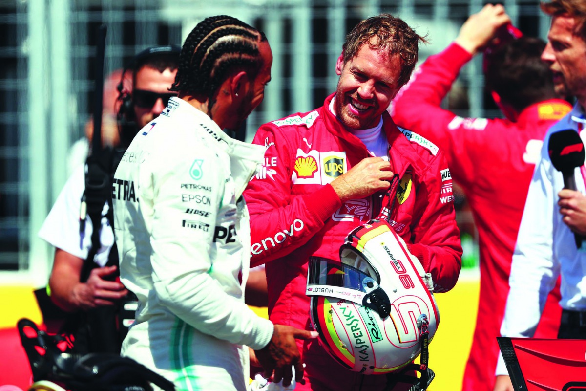 Sebastian Vettel (right) and Lewis Hamilton share a light moment during qualifying session for the F1 Grand Prix of Canada, in this June 08, 2019 file photo.