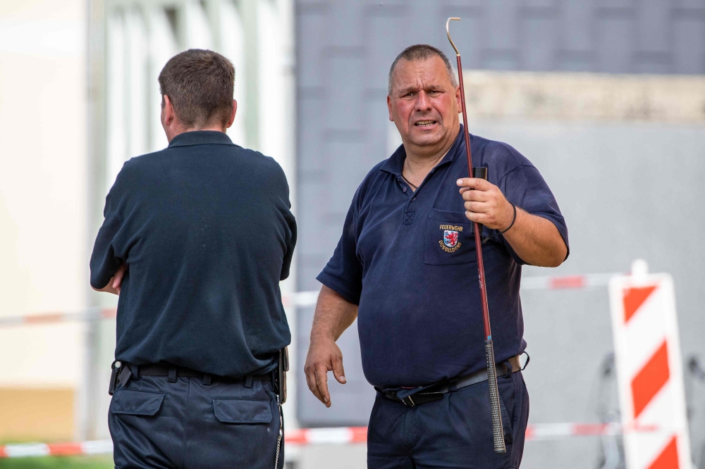 This picture taken on August 28, 2019 shows snake experts of the public order office at work in front of a residential building in Herne, western Germany, where a deadly cobra was on the loose. AFP / DPA / Christoph Reichwein 